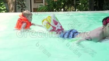 爸爸和孩子在游泳池里玩得很开心。 爸爸和儿子是室内游泳池。 父亲教儿子游泳。 儿童概念